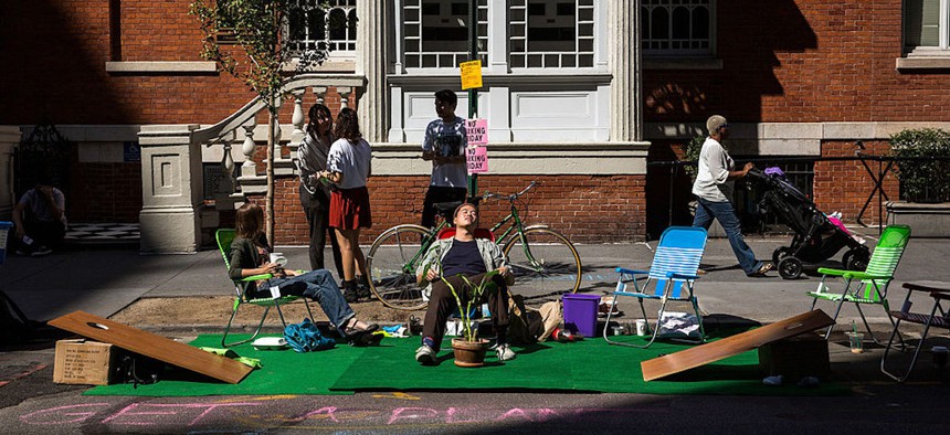 A man relaxes in a lawn chair while participating in Park(ing) Day on Sept. 20, 2013, in New York City. Park(ing) Day is an annual, international day where participants transform ordinary parking spaces into miniature public parks to bring attention to use of space, environment and reliance on cars. 