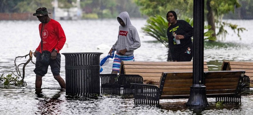 People wade through flood waters in the aftermath of Hurricane Ian in Orlando, Florida on September 29, 2022.