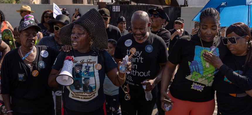 Mary Jackson, second from left, who lost her 13-year-old son Draysean Earl to gun violence, offer prayers during "Mothers in Mourning" march, passing by Nickerson Gardens on Compton Avenue in Los Angeles. 