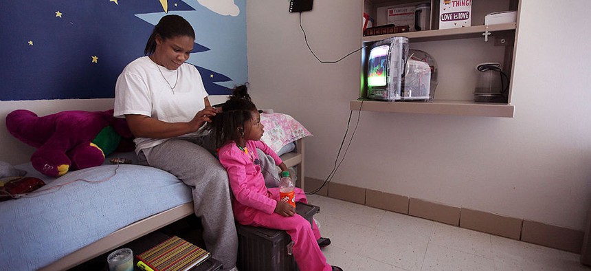 Michelle Harvey combs her daughter's hair in her room at the Decatur Correctional Center on Feb. 18, 2011, in Decatur, Illinois. Experts say allowing incarcerated parents to maintain relationships with their children can help reduce recidivism.