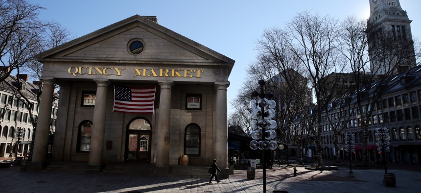 A man passes through a near empty Faneuil Hall Marketplace on Saturday morning in Boston in March 2020.
