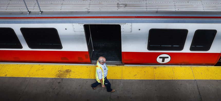 An MBTA employee walks past a Red Line train.