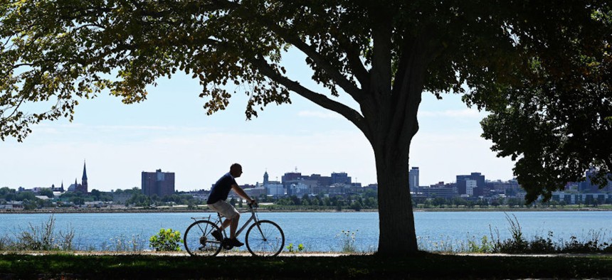 A cyclist makes his way along Back Cove Trail with the Portland, Maine, skyline in the background Friday, July 31, 2020.