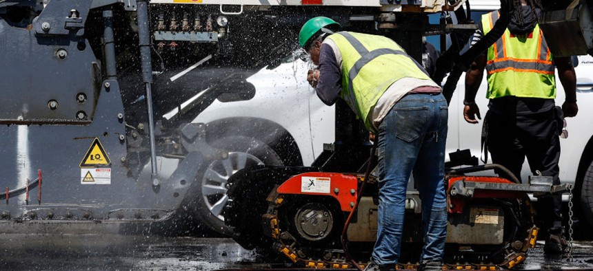 A construction worker sprays water in his face during maintenance work along Pennsylvania Avenue on July 27, 2023 in Washington, DC. 