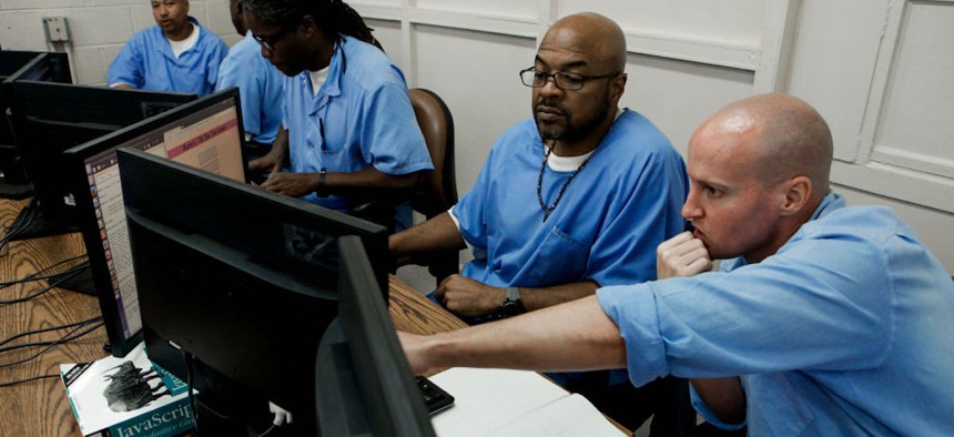San Quentin State Prison inmates Harry Hemphill (center) and Steve Lacerda (right) work on a coding assignment during a computer coding class on Nov. 13, 2014 in San Quentin, California.