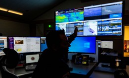 Scott Slumpff monitors computer screens showing footage from the Cal Fire agency's wildfire camera systems at the Southern California Geographic Area Coordination Center on Aug. 9, 2023 in Moreno Valley, California. The agency is using AI to help monitor wildfires.