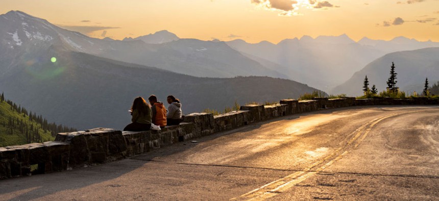 A trio eats dinner on the edge of Going-To-The-Sun Road at Glacier National Park in Montana on July 5, 2023. 