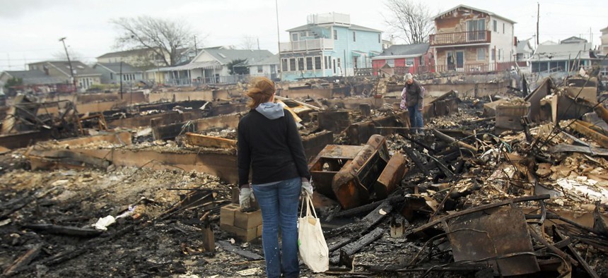 People look through the remains of homes destroyed during Hurricane Sandy October 30, 2012, in the Breezy Point neighborhood of the Queens borough of New York City.