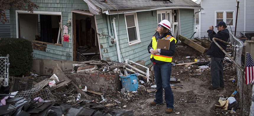 A woman with the Army Corps of Engineers and a representative from FEMA document a destroyed home on Nov. 28, 2012, in a residential area of New Dorp Beach in the Staten Island borough of New York City after Hurricane Sandy..