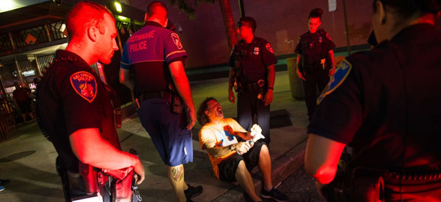 A man who is overdosing on drugs is overseen by first responders and police as they await an ambulance on Aug. 17, 2018 in in Baltimore, Maryland. 