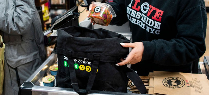 A worker packs groceries of a customer in her reusable bag as she goes shopping at a local supermarket on March 1, 2020, in New York City. New York state banned the distribution of single-use plastic bags to reduce billions of discarded bags that pollute into landfills, rivers and oceans. 