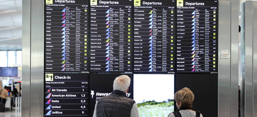 Passengers look at the list of flights at Newark Liberty International Airport ahead of the holiday travel rush in New Jersey.