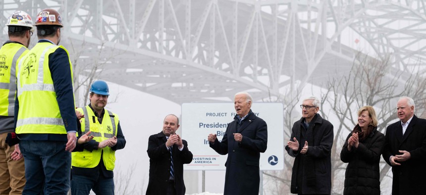 President Joe Biden (C) visits the John A. Blatnik Memorial Bridge in Superior, Wisconsin on Thursday, along with Wisconsin Gov. Tony Evers and Minnesota Gov. Tim Walz and other officials.