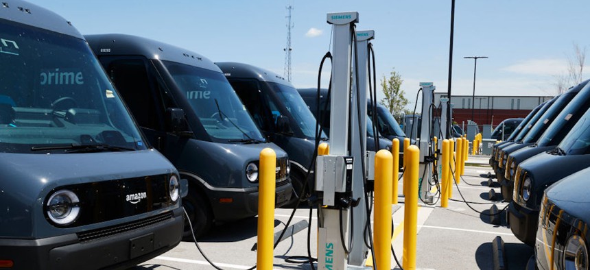  A fleet of electric delivery vehicles are seen connected to electric chargers during a launch event between Amazon and Rivian at an Amazon facility on July 21, 2022 in Chicago, Illinois.