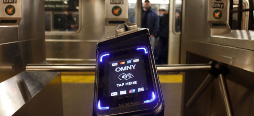 An OMNY fare reader is pictured in front of a '1 line train at the Christopher Street subway station on March 5, 2023, in New York City. 