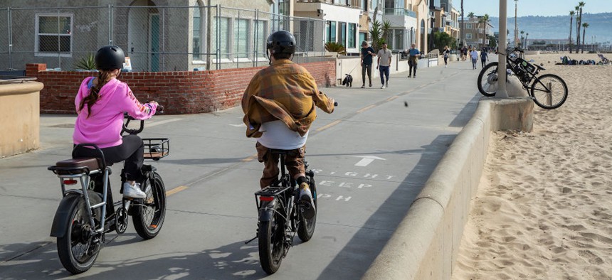 People ride e-bikes in Hermosa Beach, California, on Nov. 10, 2023.