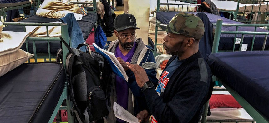 Keith Mitchell, Jr., 47, L, speaks with fellow homeless shelter resident, Ben Ralston, 52, at the Siena Francis House in Omaha, Nebraska, on Wednesday, May 2, 2018.