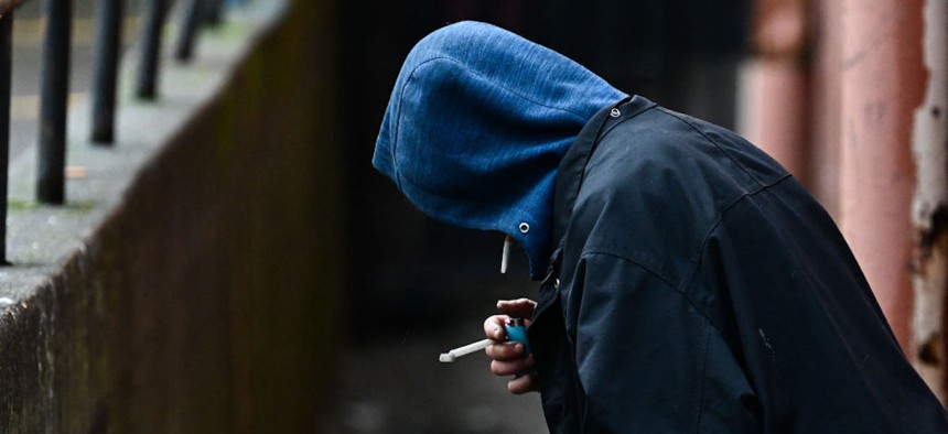 A person holds a lighter in an alleyway in downtown Portland, Oregon, on Jan. 25, 2024.