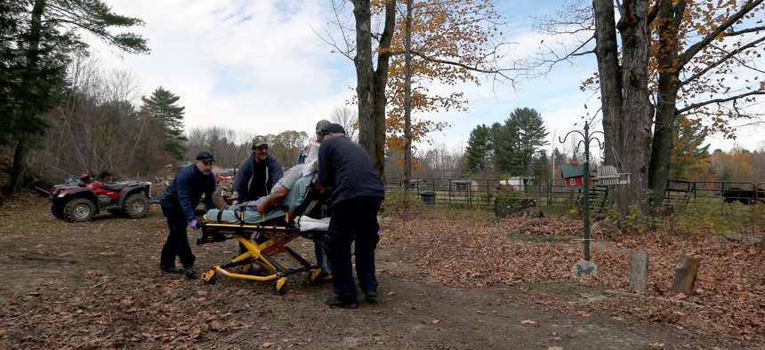 Crews from NorthStar Ambulance and Industry Fire and Rescue wheel a 69-year-old fall victim toward an ambulance for a 15-mile ride to the hospital in Farmington. Emergency medical services stretched thin across large swaths of rural Maine. 