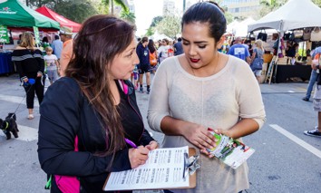 Woman taking a survey at the Carnaval Miami Latin Cultural Street Fair.