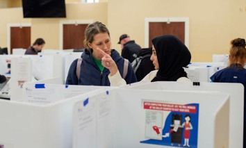 A poll worker helps a voter at the Noor Islamic Cultural Center in Columbus, Ohio, on March 19, 2024.