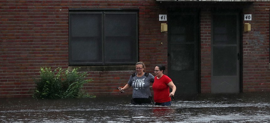 Residents wade through deep floodwater to retrieve belongings from the Trent Court public housing apartments after the Neuse River went over its banks during Hurricane Florence September 13, 2018 in New Bern, United States. 