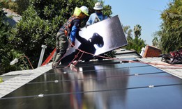 GRID Alternatives employees Tony Chang (L) and Sal Miranda install no-cost solar panels on the rooftop of a low-income household on October 19, 2023 in Pomona, California. 