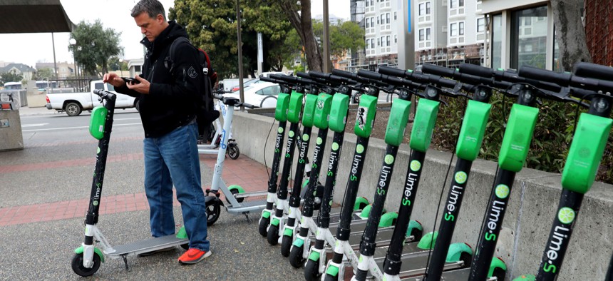 Alejandro Caminos from Valenzuela gets ready to use a Lime scooter from the Lake Merritt Bart station on Thursday, March 5, 2020, in Oakland, Calif.