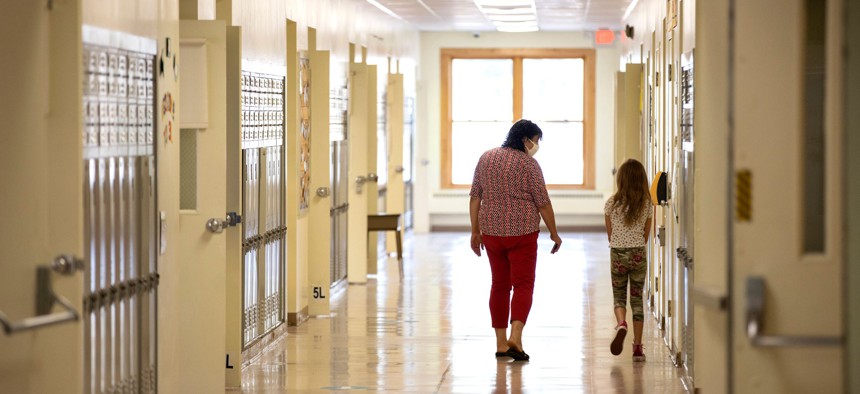 A teacher walks down the hallway while giving a tour to a prospective student on the first day of school at Loranger Memorial School in Old Orchard Beach, Maine, on Tuesday, September 8, 2020. 