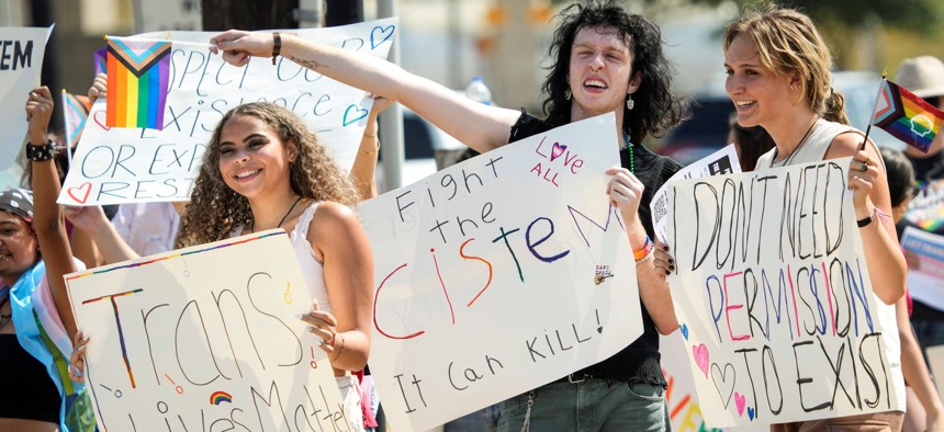 Nya Morales, left, Saturn Ferguson and Russ Russell join a student demonstration protesting against the school district's new transgender policy outside the district's educational support complex on Wednesday, Aug. 30, 2023 in Katy, Texas.