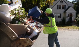 A worker for the Reading Department of Public Works in Massachusetts picks up recycling.