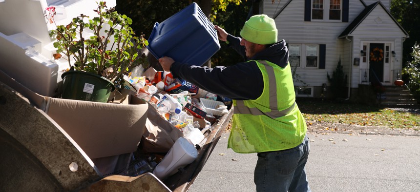 A worker for the Reading Department of Public Works in Massachusetts picks up recycling.