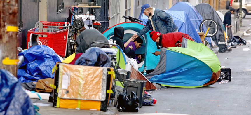 Homeless people consume illegal drugs in an encampment along Willow St. in the Tenderloin district of downtown San Francisco on Thursday, Feb. 24, 2022.