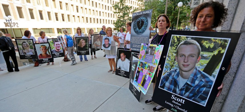 Demonstrators hold up signs that feature photos of their loved ones they lost in the opioid epidemic protest outside the Suffolk Superior Court on August 2, 2019, in Boston, Massachusetts.
