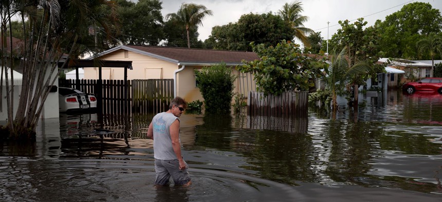 A person walks through a flooded street on April 13, 2023 in Fort Lauderdale, Florida. 