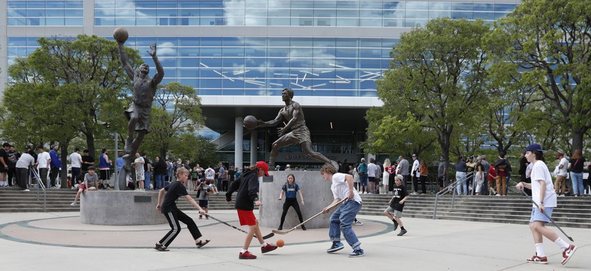Children play stick hockey in front of the Delta Center in Salt Lake City, which is intended to be the home of a new NHL team next year.