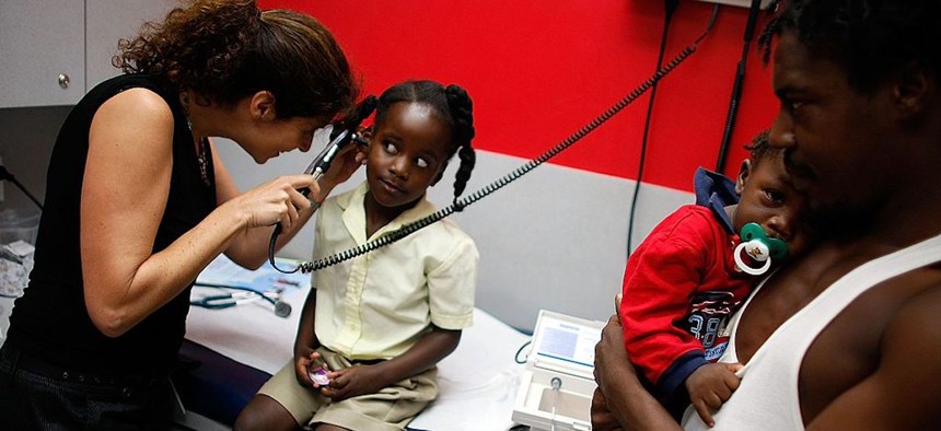 University of Miami Pediatrician, Dr. Gwen Wurm, does a checkup on Christina Brownlee, 5, as her father, Isaac Eady, holds her brother, Isaiah Eady, 1, at the University of Miami Pediatric clinic October 3, 2007, in Miami, Florida.
