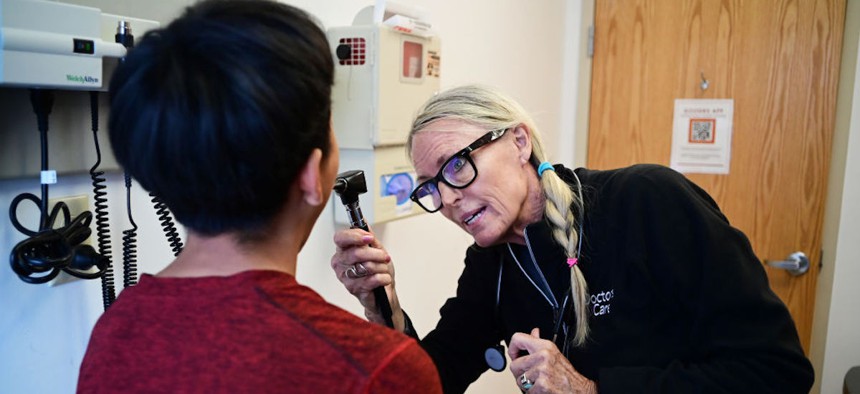 Sue Covington, right, exams a patient at Doctors Care clinic in Littleton on Thursday, May 30, 2024.