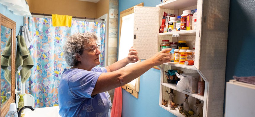 Trudy Zimmerman, then 65, pulls out medications from her medicine cabinet at her home in Burlington, Washington, on March 5, 2023. 