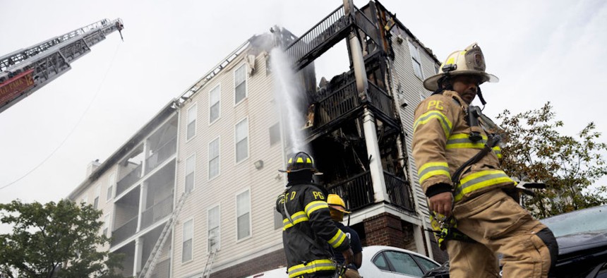  Prince Georges County firefighters spray water on the Wynfield Park Apartments after a fire broke out at the Beltsville, Maryland, complex on the morning of August, 21, 2023.