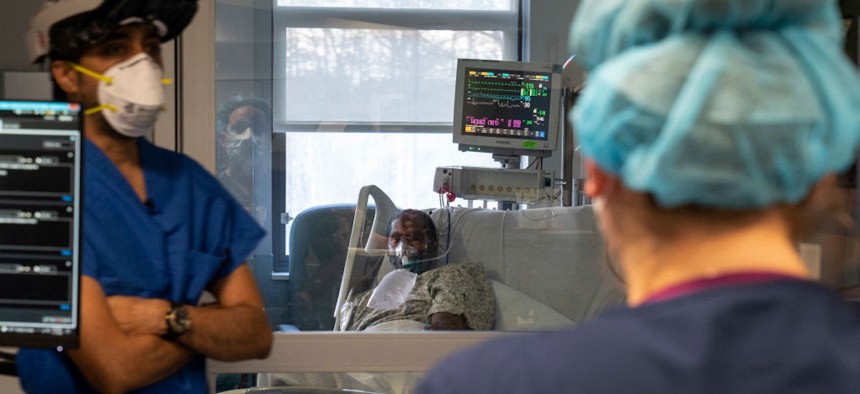 Doctor and Director of Critical Care Kanak Patel, left, prepares to check on Steve Byrd, center, a patient suffering from Covid in the Intensive Care Unit at Doctors Hospital on January 14, 2022, in Lanham, Maryland. 