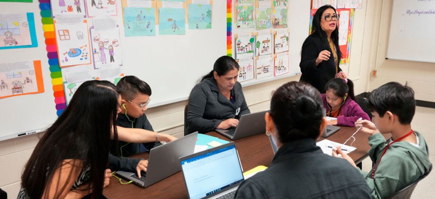 Sheila Rodriguez, Reading Manager at UH Downtown E-Library, standing, works with parents and students on creating their bilingual stories and exercises on Dec. 6, 2023, at Black Elementary in Houston, Texas. 