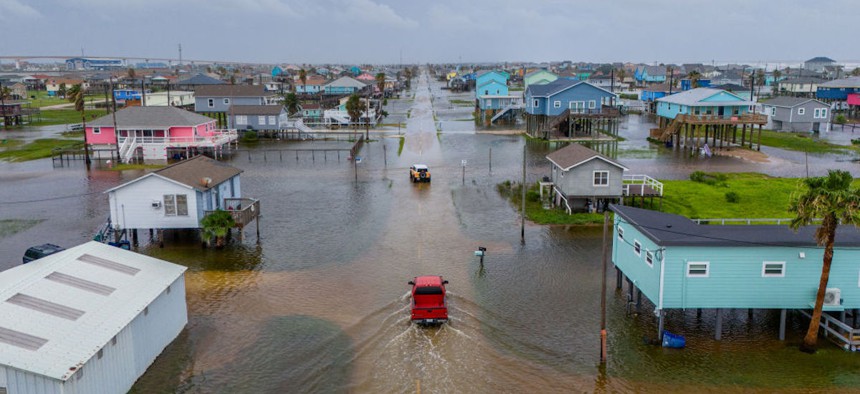 In this aerial image, vehicles drive through flooded neighborhoods on June 19, 2024, in Surfside Beach, Texas. 