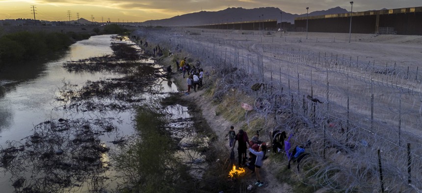 immigrants warm themselves before campfires after wading through the Rio Grande from Mexico into the United States in March in El Paso, Texas. 