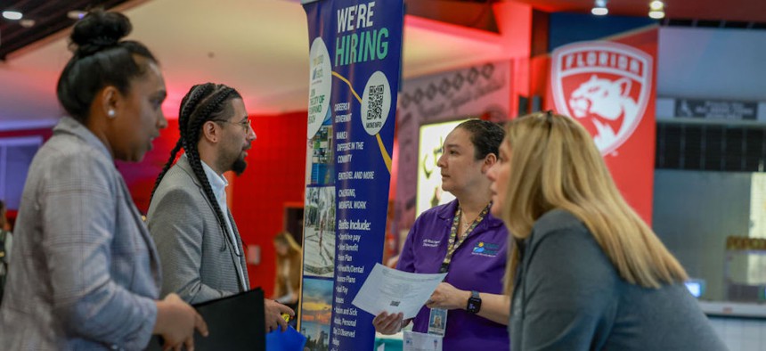 Jay Santana speaks to Elizabeth Brunner, a recruiter for the City of Pompano Beach, during the JobNewsUSA.com Job Fair held at the Amerant Bank Arena on June 26, 2024, in Sunrise, Florida.