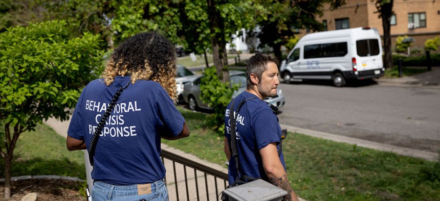 Shamso Iman, left, and Dane Haverly, with the Behavioral Crisis Response team, leave the scene after responding to a distress call in Minneapolis on Tuesday, July 11, 2023.