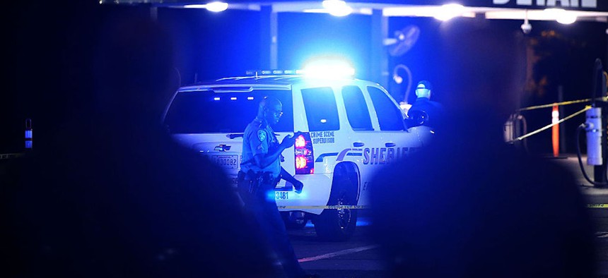 Police officers stand near the scene of where three police officers were killed this morning on July 17, 2016, in Baton Rouge, Louisiana.