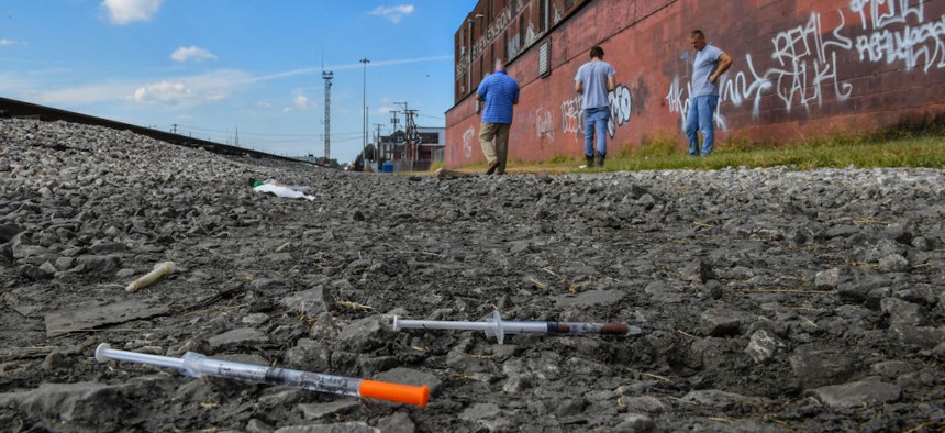  Two partially used syringes and needles are seen as Rocky Meadows, left, former addict and founder of Lifehouse treatment and recovery center, walks with two former addicts along rail tracks where addicts use drugs on Oct. 2, 2019, in Huntington, West Virginia. 