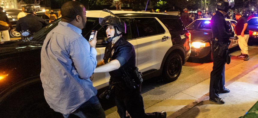 A protester faces off with police officers during a rally against the fatal police assault of Tyre Nichols on January 27, 2023 in Los Angeles.