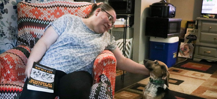 Richmond, Virginia, resident Jana Hobbs pets her beagle “Bug,” in her apartment on Aug. 12, 2024. 